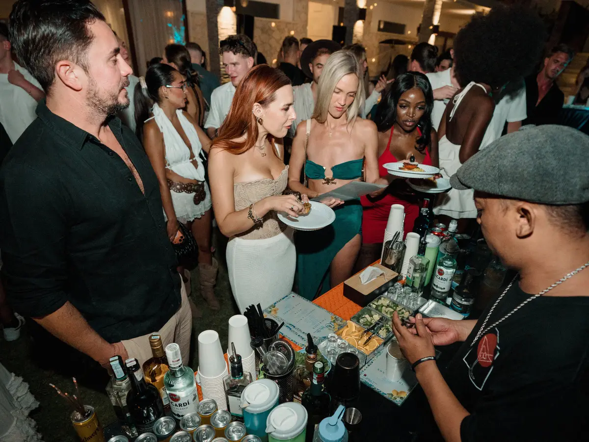 Guests at the bar while the bartender makes drinks