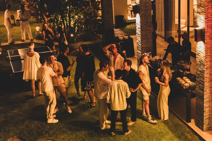 The garden full of guests, talking and laughing under the trees