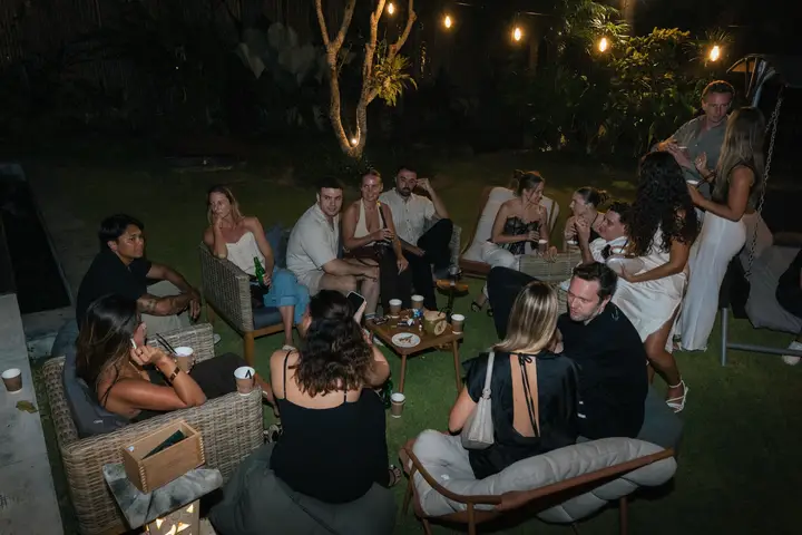 Guests sitting on lounge chairs on the lawn under string lights