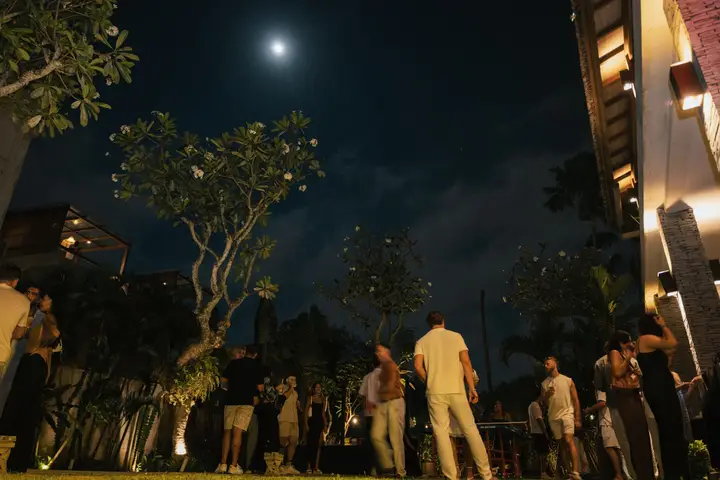 The garden under a full moon, guests between the trees