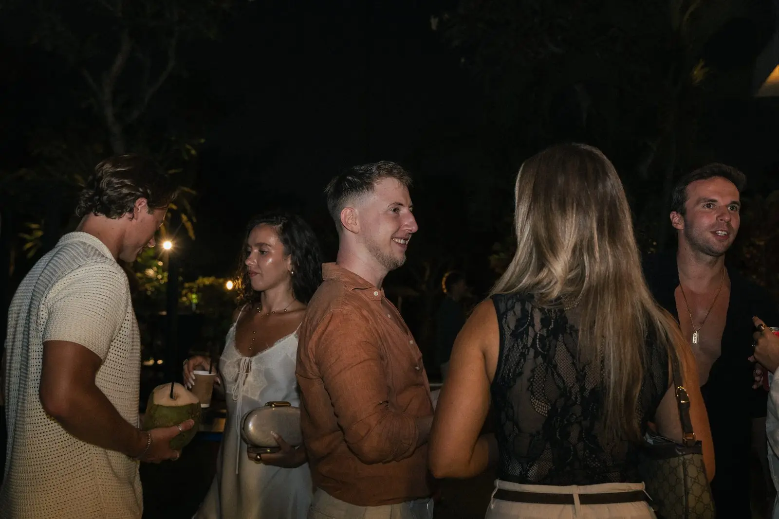 Friends talking in the garden, holding coconuts