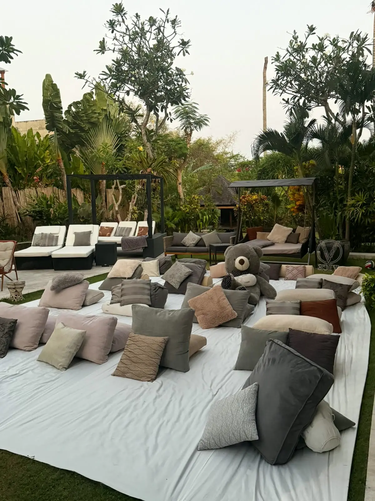 Floor cushions laid out on the lawn before guests arrive